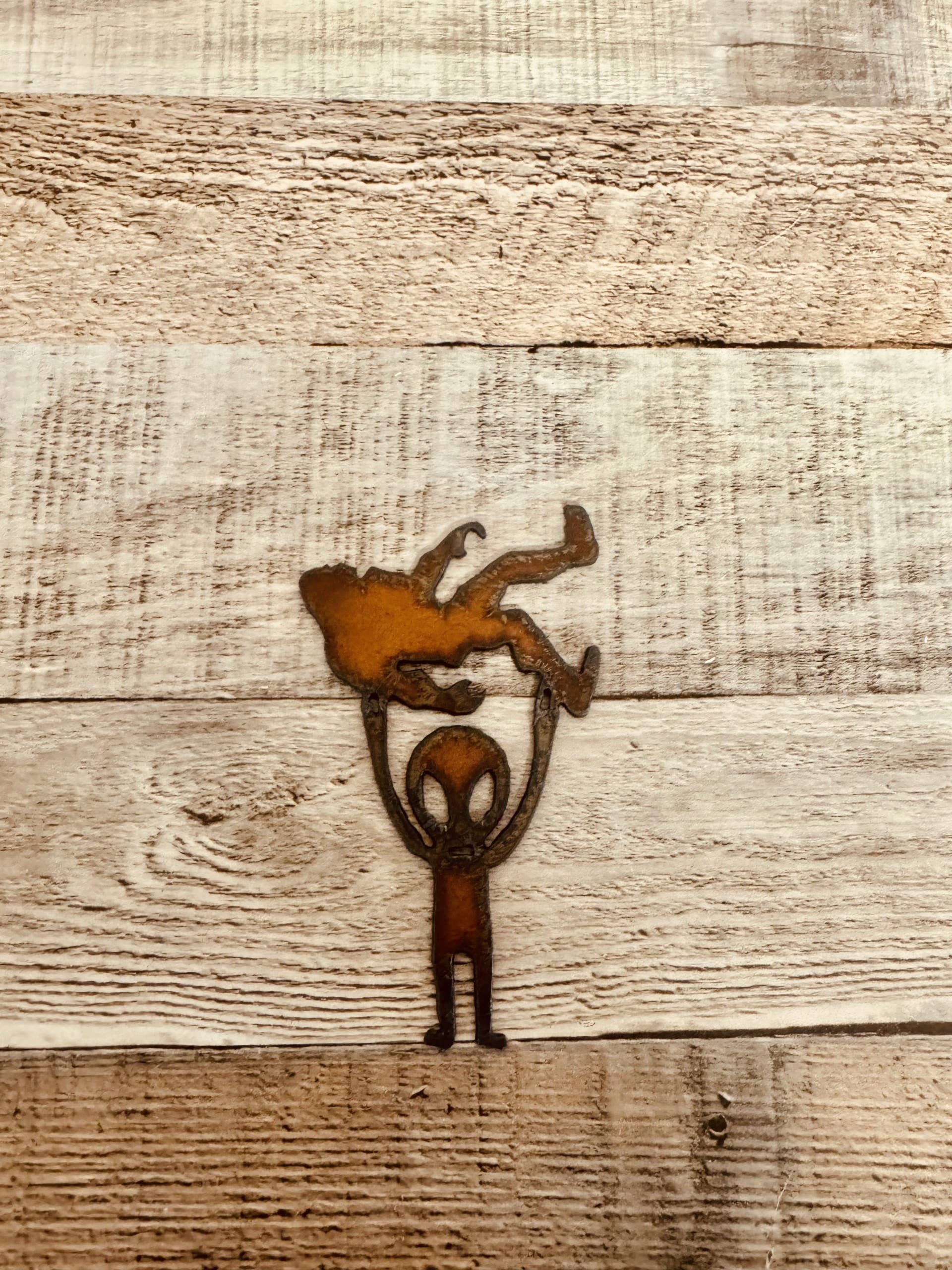 Alien Holding Bigfoot Rustic Metal Magnet